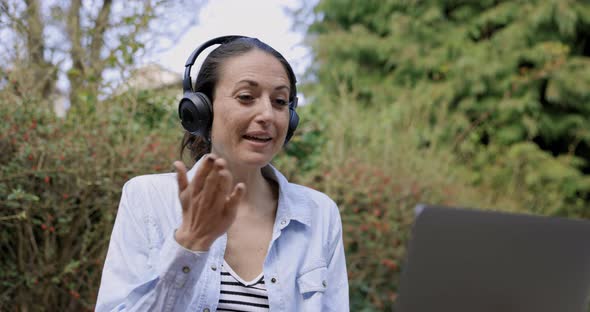 Woman with headphones ending video call with blow kiss