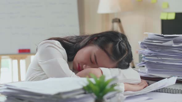 Close Up Of Tired Asian Woman Yawning Before Sleeping While Working Hard With Documents