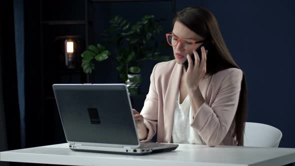 Successful Businesswoman Using Laptop Talking on Phone Making Business Call at Work Smiling Female