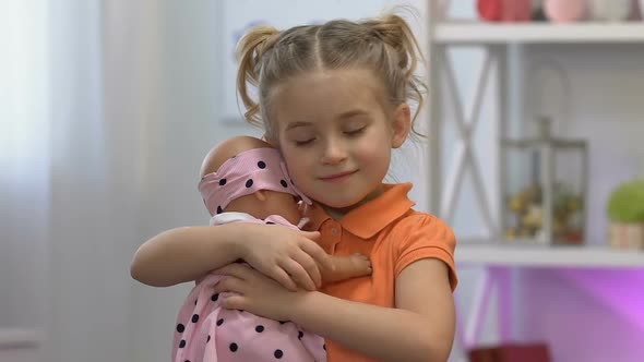 Cute Girl Tenderly Embracing Favorite Baby Toy, Dreaming About Little Sister
