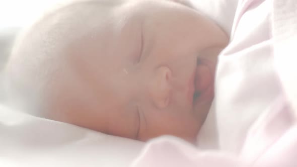 Newborn Baby with Blue Eyes Falling Asleep