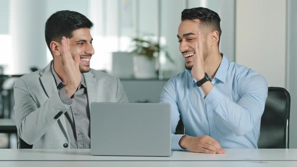 Two Arab Young Male Businessmen Sitting in Modern Office Satisfied with Result of Negotiations