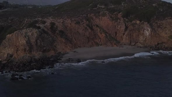 AERIAL: Flight Over Malibu, California View of Beach Shore Line Pacific Ocean at Sunset with