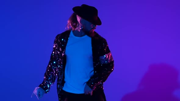 Young Stylish Man Dancing in Style, Spotlight on a Blue Background. Close Up, Slow