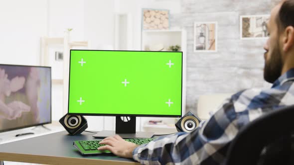 Zoom in Shot of Man Working on Green Screen PC