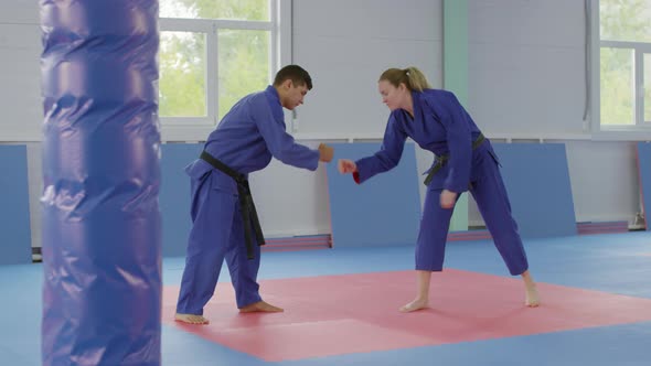 Male and Female Jujitsu Athletes Greeting Each Other and Preparing for Fight