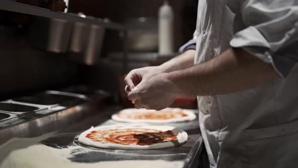 Male Chef Hands Making Pizza in the Pizzeria Kitchen