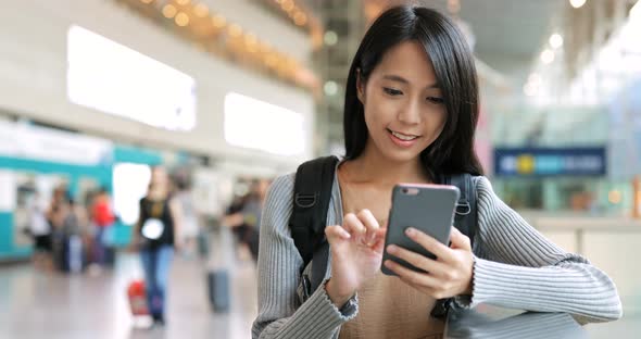 Woman using mobile phone in station 