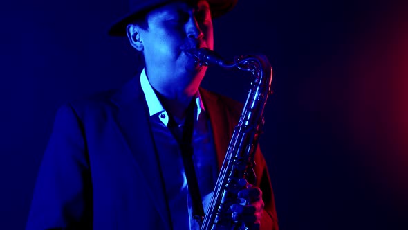 Man Musician in Hat and Suit Plays the Saxophone in Studio Neon Light