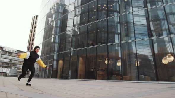 Young Man and Woman Performing Parkour Stunts Together Outdoors