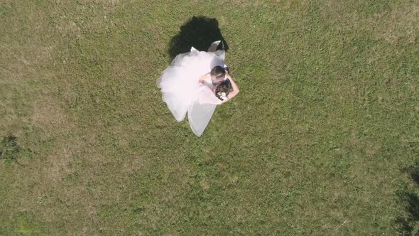 Top down aerial view of wedding couple spinning in a park 28