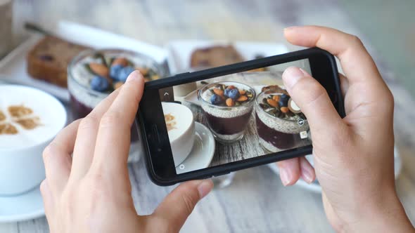 Woman Hands Taking Picture Of Food With Smart Phone. Vegan Chia Pudding For Breakfast.