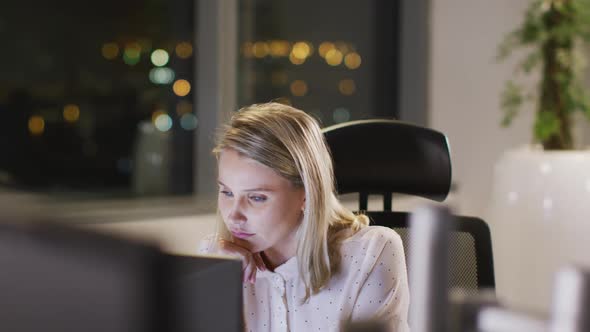 Professional businesswoman working while sitting on her desk in modern office in slow motion