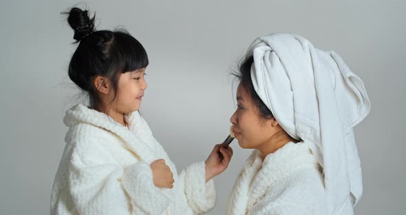 Cute Little Asian Ethnic Girl Daughter and Mom Wear Bathrobes After Bathing Spa Enjoy Cleanliness