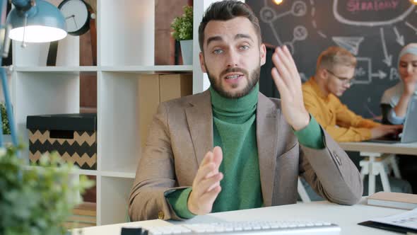 Young Handsome Businessman Making Video Call Fom Office Discussing Project Online