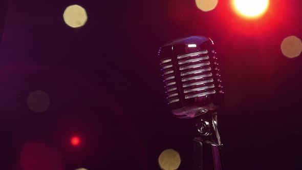 Vintage Microphone Against Dark Blurry Background with Bright Flashing Lights