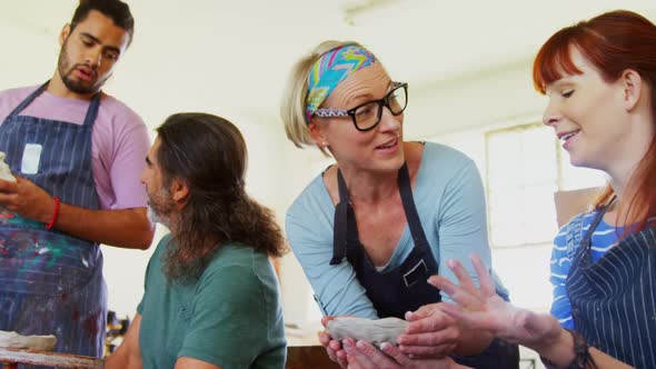 Drawing teacher assisting artist in pottery 4k