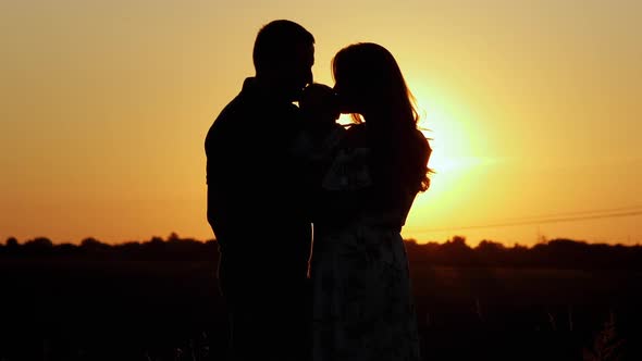 Unrecognizable Silhouette of Family at Sunset Parents Hug and Kiss Their Child Family Values and