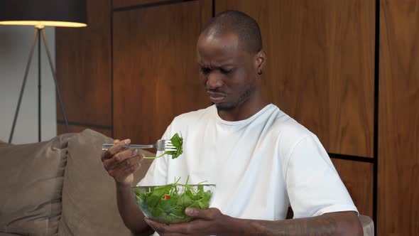 Young Black Man Forcing Himself to Eat Salad Dissatisfaction Diet for Weight Control