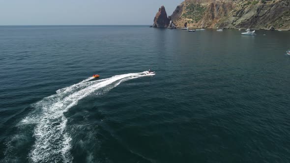 Happy People Swim on Air Mattress Behind a High Speed Water Bike