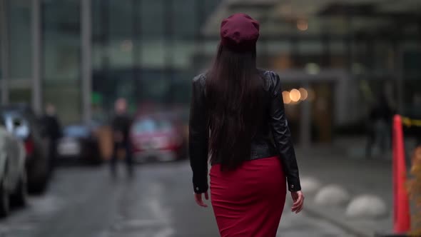 a Brunette with Long Hair in a Black Leather Jacket a Red Skirt and a Burgundy Cap Goes to a Modern