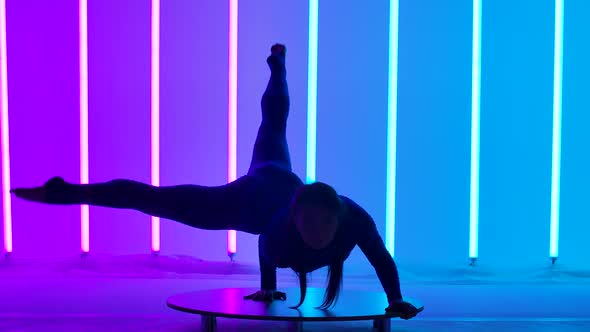 An Attractive Woman Performs a Handstand Moves Her Legs and Splits Them Into a Split