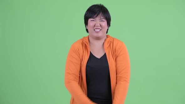 Happy Young Overweight Asian Woman Getting Good News Ready for Gym