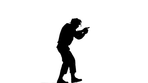 Man Flee Holding a Gun in Hand. Silhouette