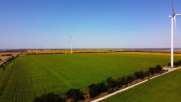 Aerial drone view of a flying over the wind turbine and agricultural fields