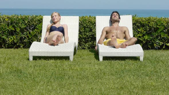 Young couple sleeping on sun loungers