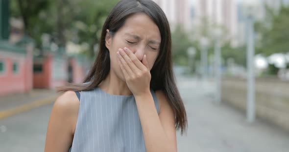 Woman feeling nose allergy in city 