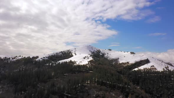 Scenic landscape of Kolitza Mount summit covered in Snow, Aerial towards shot