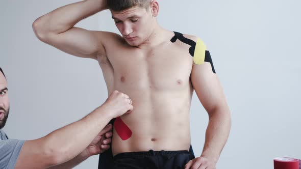 Athlete Receiving Kinesiology Tape Therapy From Therapist in Hospital