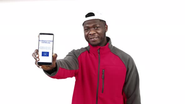 African American Showing COVID Vaccine Certificate with Thumb Up White Background  Waistup Shot