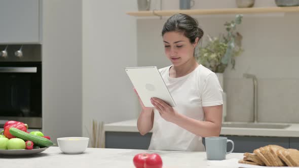 Young Indian Woman Using Tablet in Kitchen