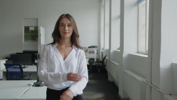 Lady Stands in Office and Smiles on the Camera