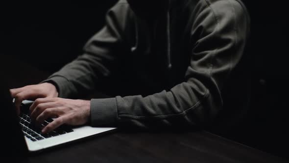 Pedestal Shot of Hacker Man Hacking Web Site or Engaging Hacking Into Security Systems at Dark Room