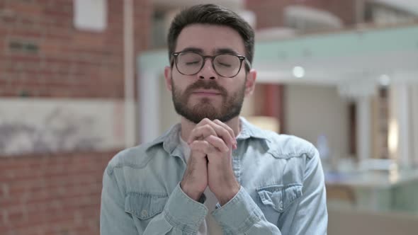 Portrait of Spiritual Young Male Designer Praying 