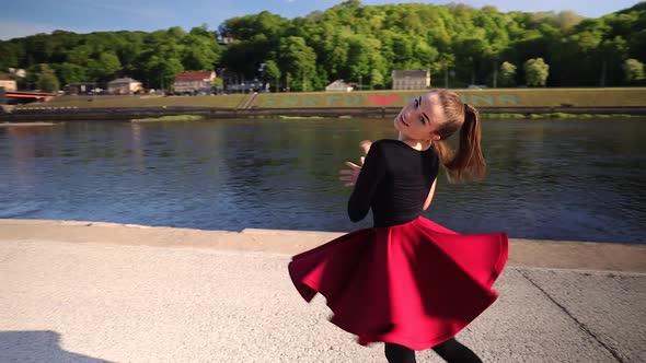 Close up of a attractive Caucasian dancer dancing in front of a river in the evening