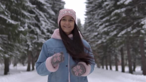 The Girl Runs Through the Winter Forest in a Good Mood and Smiles. Slow Motion 