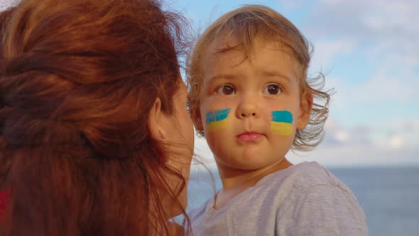 Close Up Portrait Little Baby and Mom with Flag of Ukraine on Face