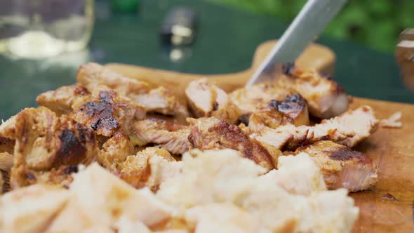 Friends Tasting Fresh Grilled Meat from Wood Board at Summer Camping