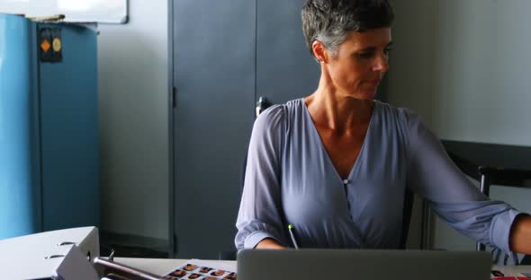 Female graphic designer using graphics tablet at desk 