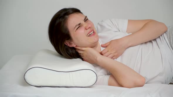 A Woman Wakes Up with a Sore Neck Throws Away a Pillow and Goes to Bed on Her Belly