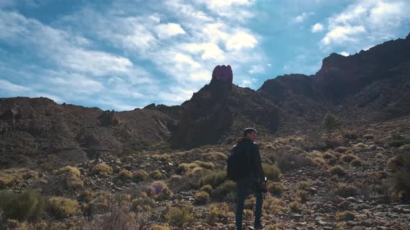 Tourist Man Walk Through the Mountains of Solidified Lava in the Teide Volcano National Park on the