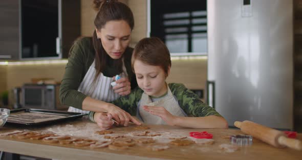 Young Mother and Son Cooking Cookies Together in the Kitchen