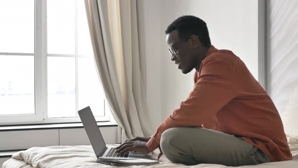 AfricanAmerican Man Screams with Happiness Near Laptop