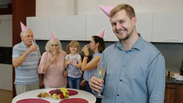 Birthday Man Holding Glass of Champagne Looking at Camera. Father Celebrating Anniversary Holiday