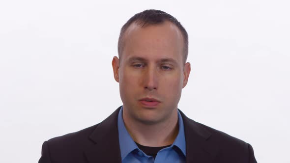 Man gets angry and curses at camera with hand gestures on white background.