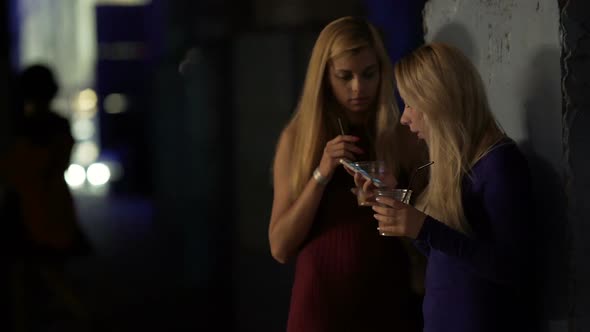 Best Female Friends Drinking Cocktails Outside Night Club and Calling a Taxi